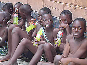 Time for lunch - traditional dancers take time to drink orange juice in coca-cola bottles.
