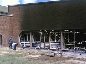 University of Zimbabwe officials inspect the building that is suspected to have been petrol bombed
