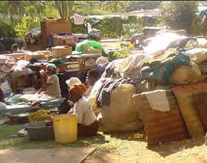 Victims take refuge with their belongings in a local church yard