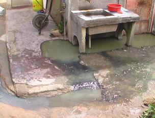 Stagnant pools of sewage form outside homes