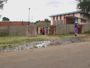 The gate to a nursery school opens onto an area of stagnant raw sewerage