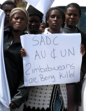 Poster reads: "SADC, AU & UN - Zimbabweans are being killed"